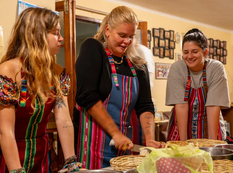 Students in colourful aprons preparing food together
